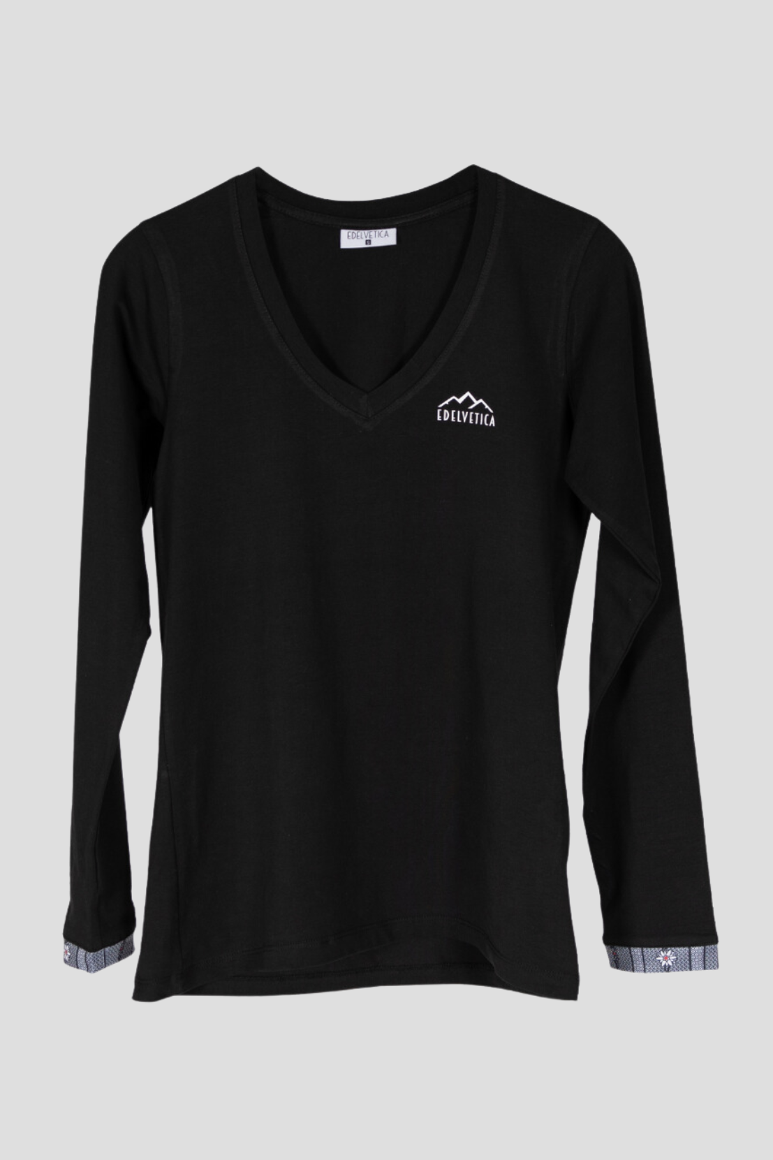 Damen-Langarm T-Shirt von Edelvetica mit Edelweiss-Armabschluss. Das Shirt hat einen V-Ausschnitt und ist aus einer weichen Baumwollmischung mit einem kleinen Anteil Elasthan gefertigt, was für Komfort und eine gute Passform sorgt. Einfaches, aber stilvolles Design, geeignet für lässige Outfits.
