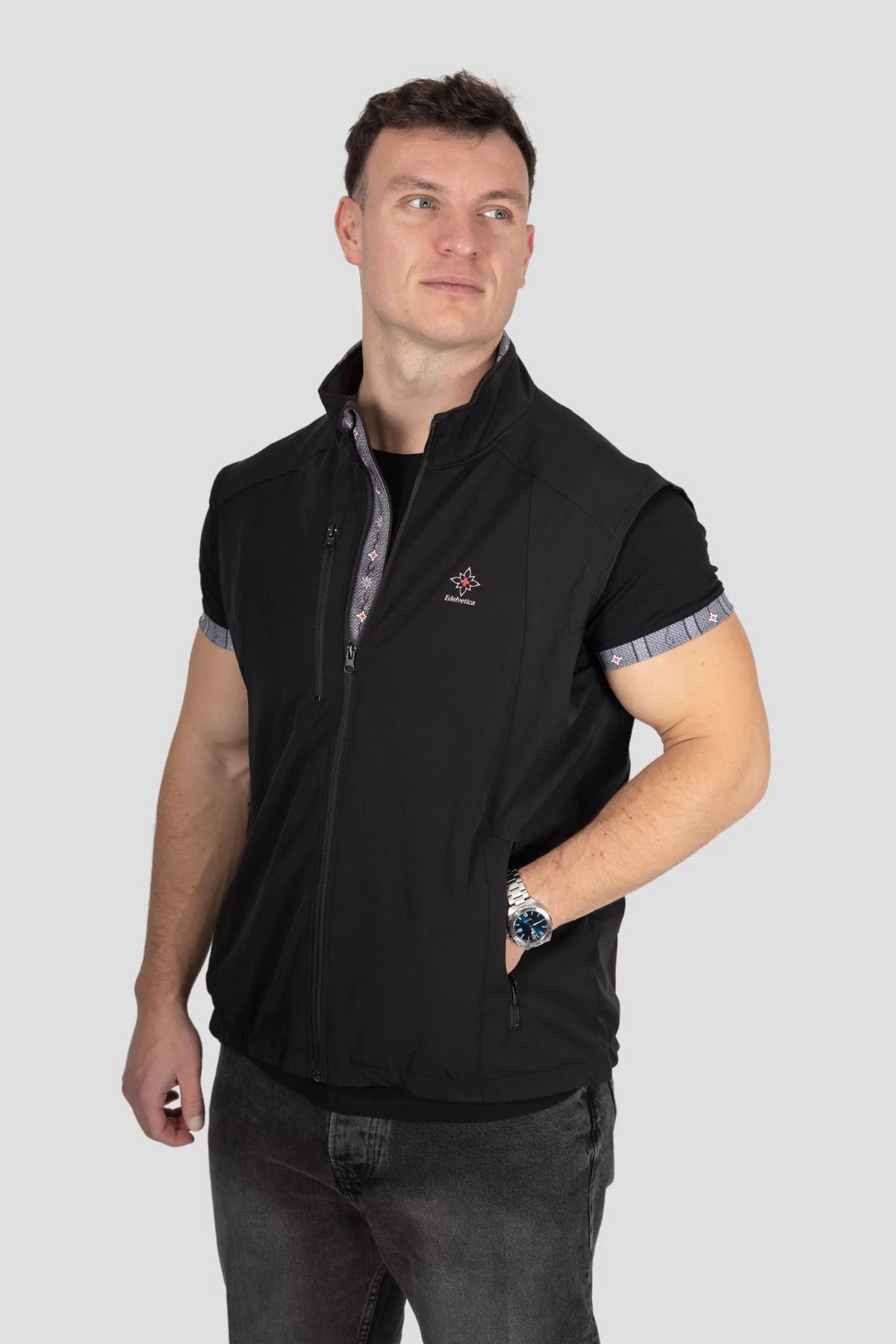 Softshell Gilet Edelweiss Herren von Edelvetica, schwarze Weste mit grauem Edelweiss-Muster, wind- und wasserdicht, stilvoll und funktional für Outdoor und Alltag.