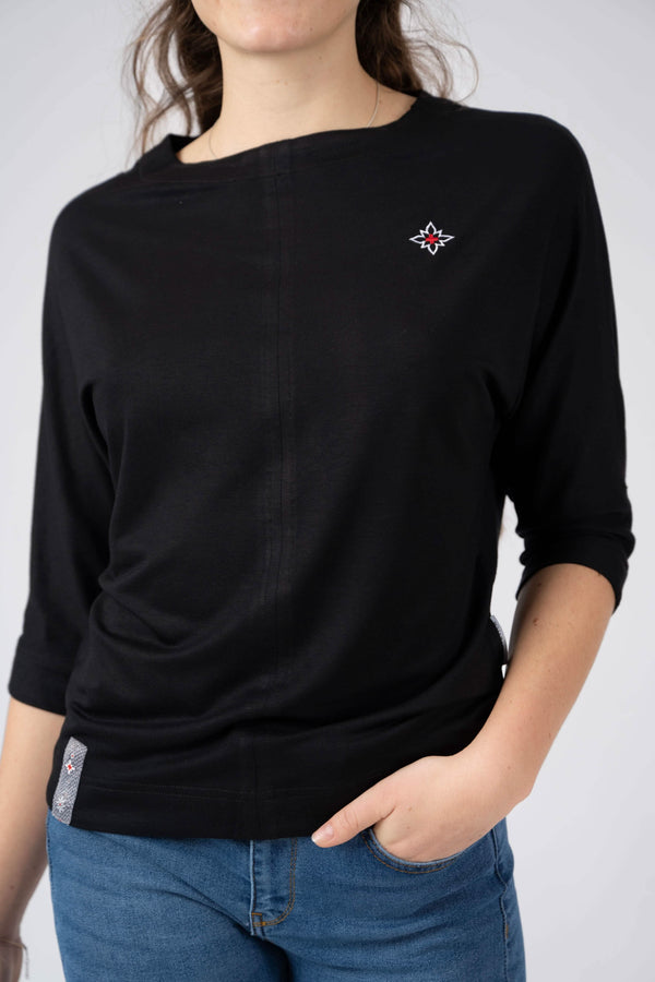 Damen Edelweiss Fledermaus-Shirt von Edelvetica, ein modisches und luftiges Oberteil. Das Shirt kennzeichnet sich durch seinen Fledermausärmel-Stil und ein elegantes Edelweiss-Muster, das Tradition und Modernität vereint. Ideal für einen entspannten, doch stilvollen Look, der sowohl Alltagskomfort als auch einzigartiges Design bietet.