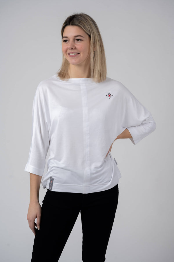 Damen Edelweiss Fledermaus-Shirt von Edelvetica, ein modisches und luftiges Oberteil. Das Shirt kennzeichnet sich durch seinen Fledermausärmel-Stil und ein elegantes Edelweiss-Muster, das Tradition und Modernität vereint. Ideal für einen entspannten, doch stilvollen Look, der sowohl Alltagskomfort als auch einzigartiges Design bietet.